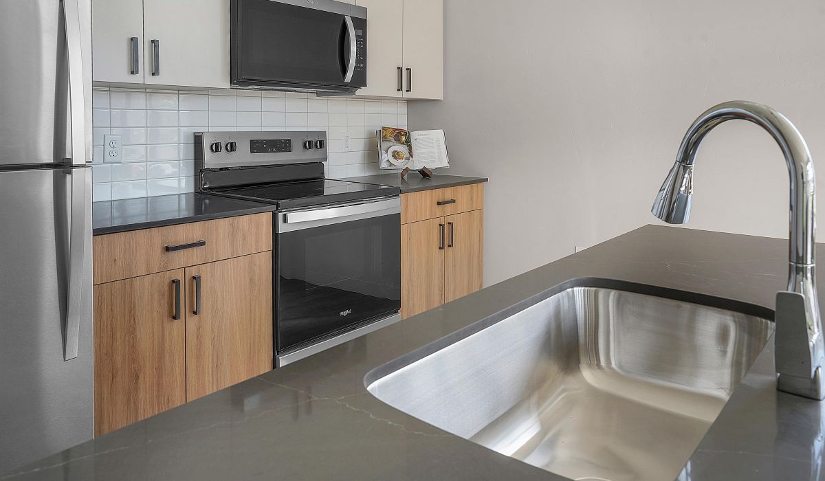 Modern apartment kitchen with stainless steel appliances at The Whitney in Salt Lake City, Utah